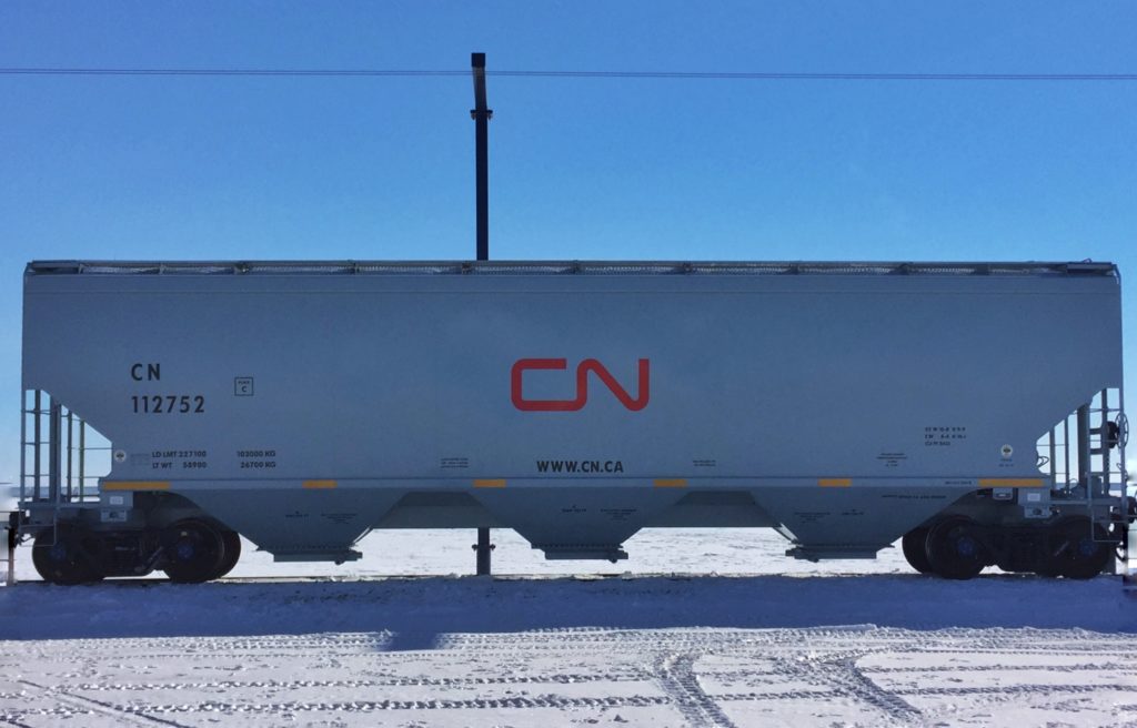 a close up photo of a new, silver, grain hopper car owned by Canadian National Railways, in Vegreville, Alberta