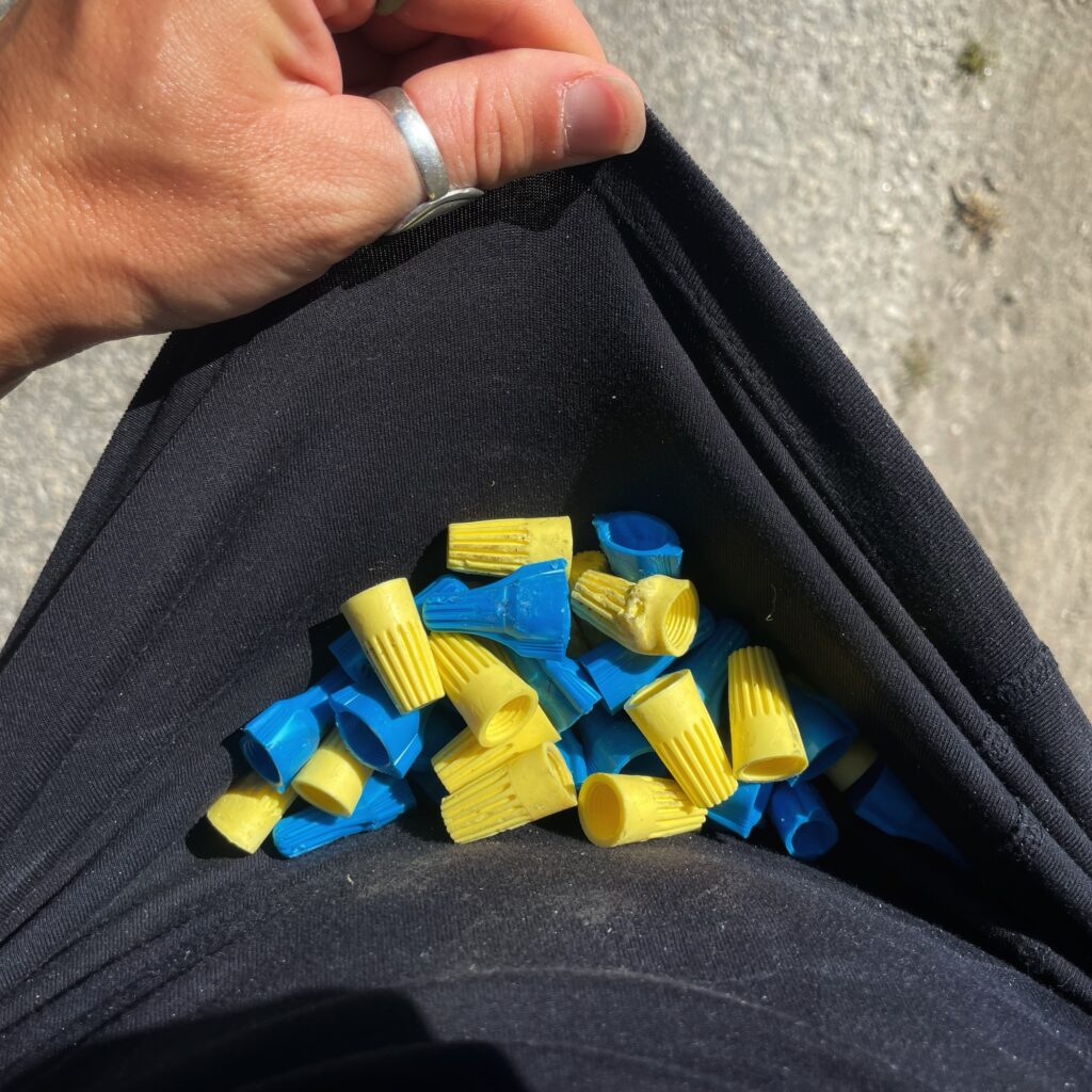Blue and yellow plastic twist-on wire connectors collected in my black running shirt.