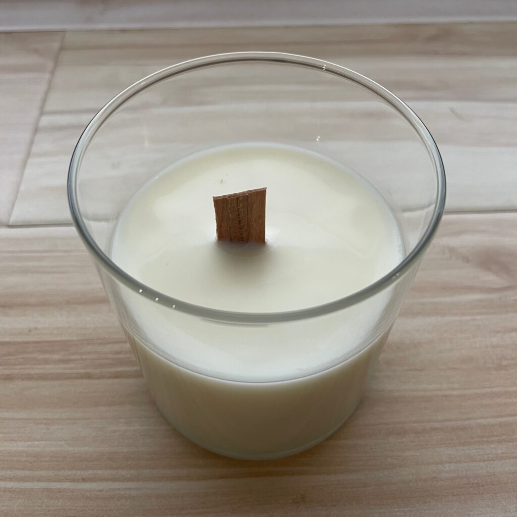 A candle refill in a glass jar with a wooden wick.