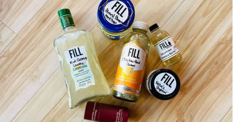 Community jars refilled with various products, laid out on a wooden floor.